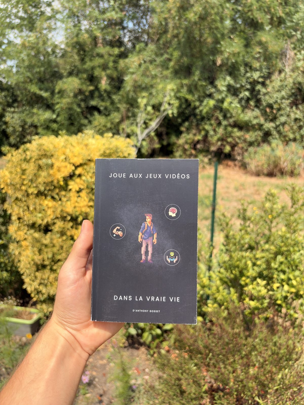 Le livre tenu en main devant un lac